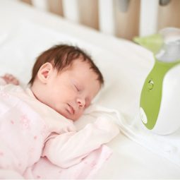 Otwórz zdjęcie noworodka leżącego w łóżeczku obok przenośnego aspiratora do nosa Nosiboo Go