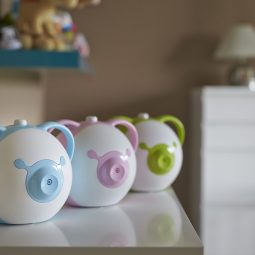 Otwórz zdjęcie elektrycznych aspiratorów do nosa Nosiboo Pro w 3 wersjach kolorystycznych stojących na półce w pokoju dziecięcym