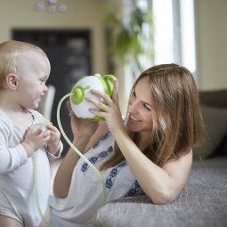 Otwórz zdjęcie małego chłopca z mamą, obok innowacyjny elektryczny aspirator do nosa Nosiboo Pro